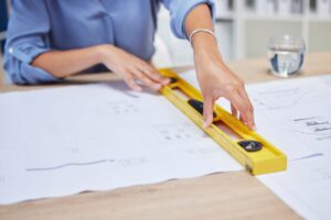 Professionnel mesurant un espace de bureau avant la création d’un agencement sur mesure.