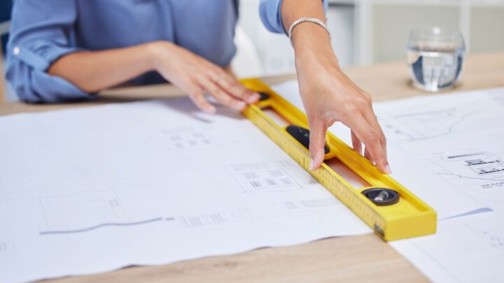 Professionnel mesurant un espace de bureau avant la création d’un agencement sur mesure.